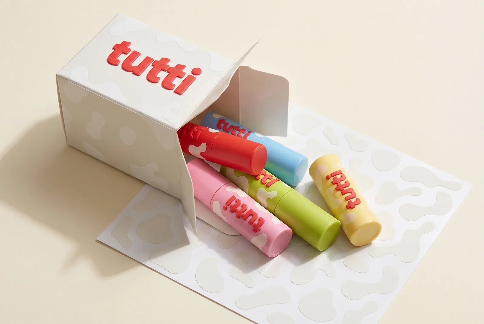 milk-carton mailer with five tutti lipstick tubes spilling out onto a sticker sheet